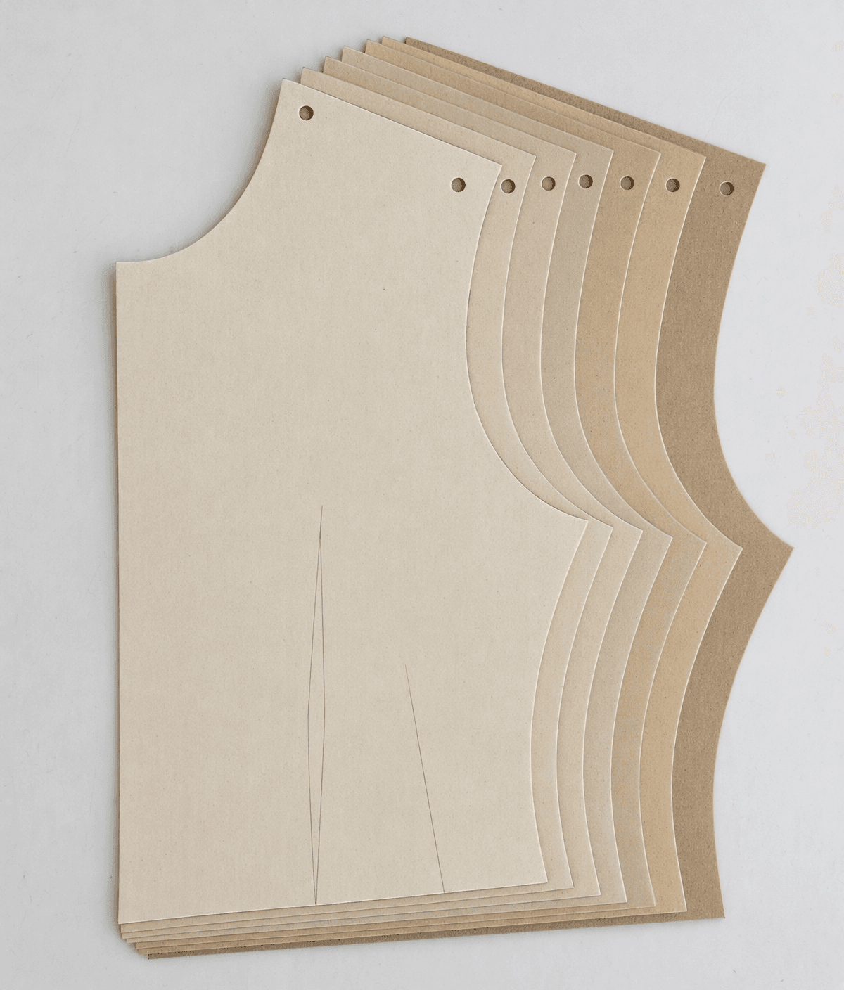 The same bodice front cut at nested sizes, fanned out so the grade is visible